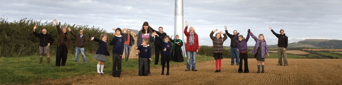 People celebrating their green energy project's grand opening of a wind turbine farm