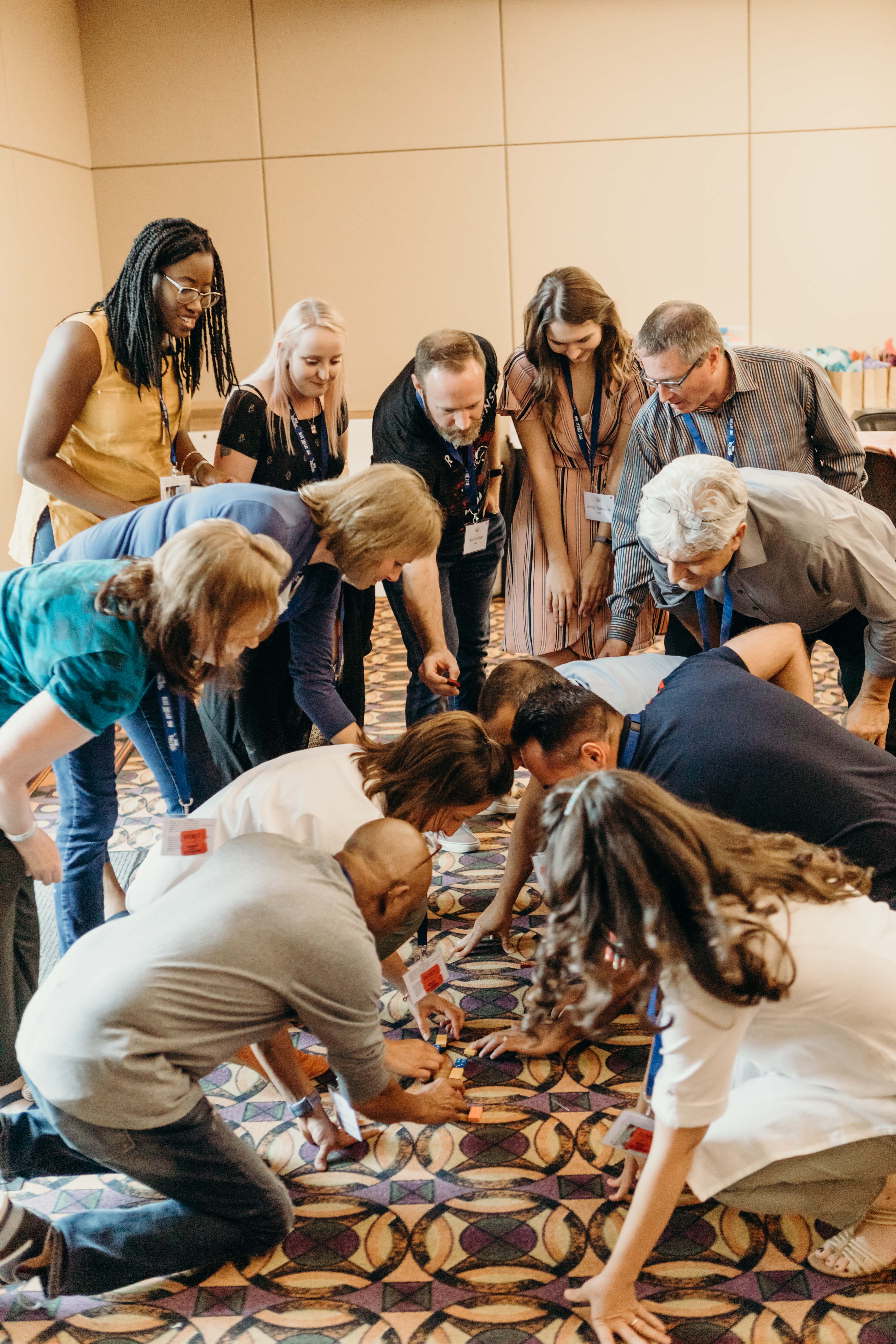 group collaborating and exploring a topic or challenge by doing an interactive exercise with paper on a carpet